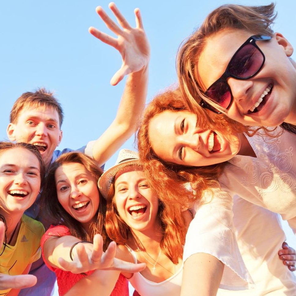Glückliche junge Menschen lachen in die Kamera - Urlaubszeit